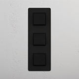 Interruttore a Bilanciere Verticale Triplo in Bronzo Nero - Strumento Moderno per la Gestione della Luce su Sfondo Bianco