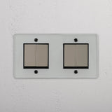Interruttore bilanciere doppio a quattro posizioni completo in nichel trasparente lucido nero: gestione della luce su sfondo bianco.